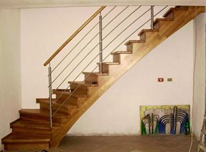 Dřevěné interiérové schodiště s ohýbanou bočnicí a nerezovým zábradlím